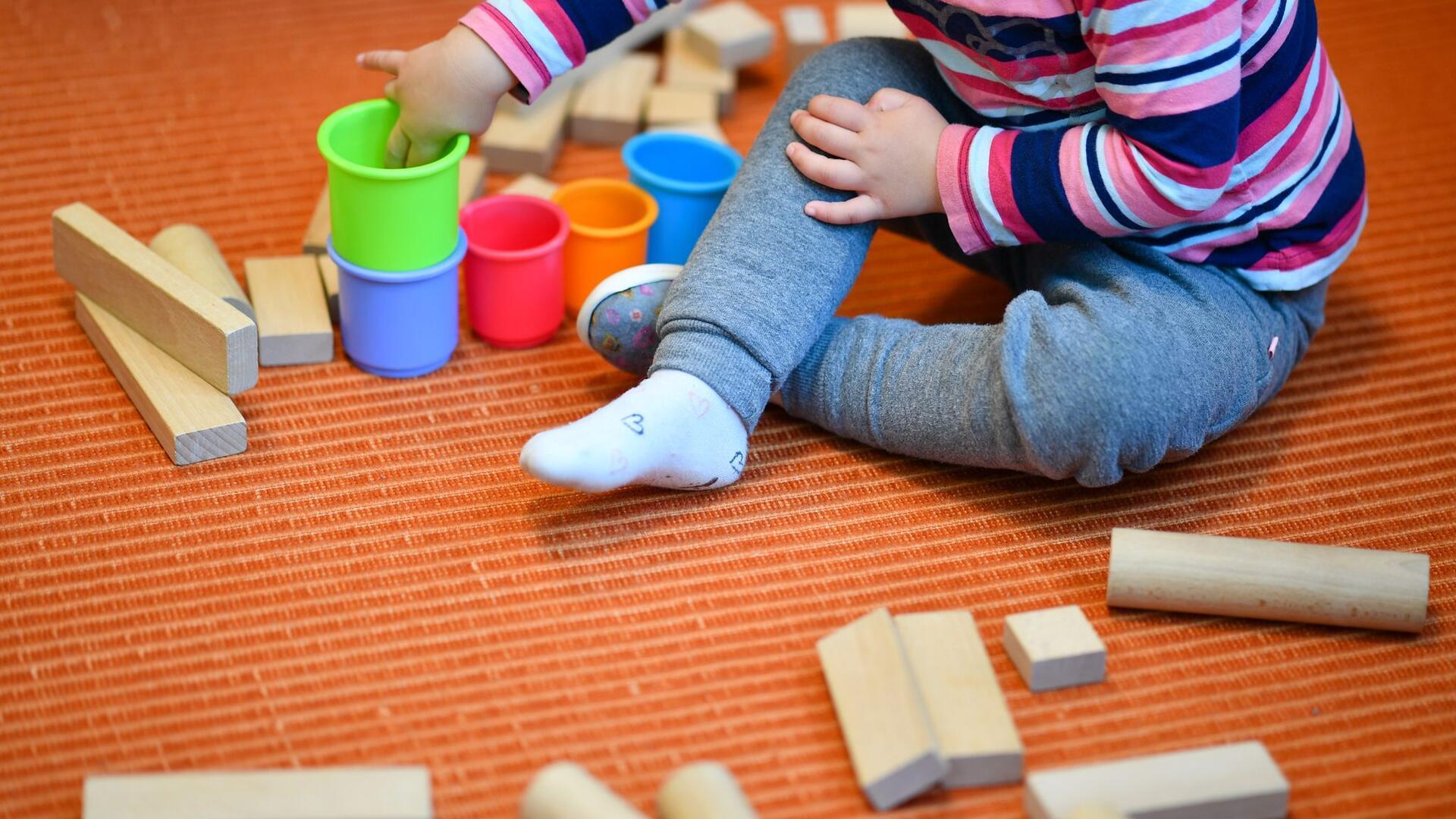 Kind spielt mit Bauklötzen und Bechern