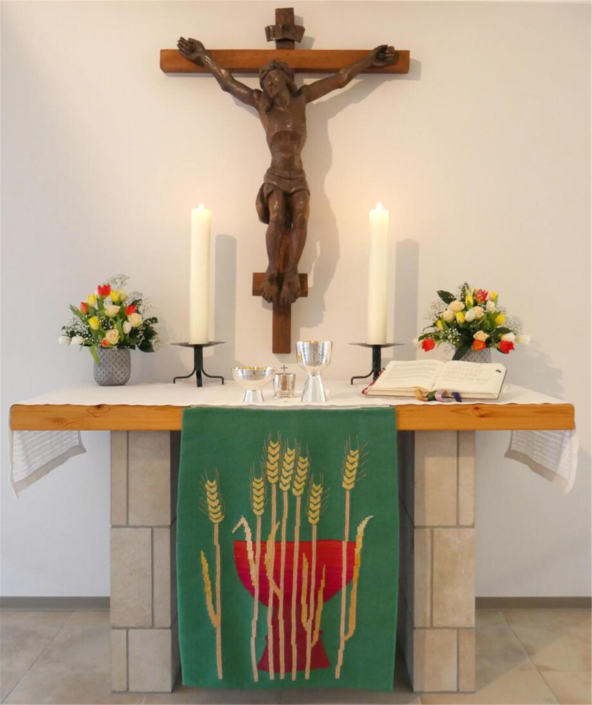 Auf einem Altar stehen zwei brennende Kerzen.