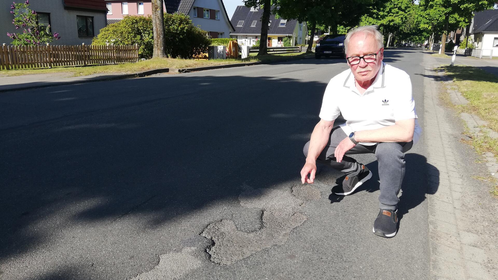 Ein Mann zeigt auf Schlaglöcher