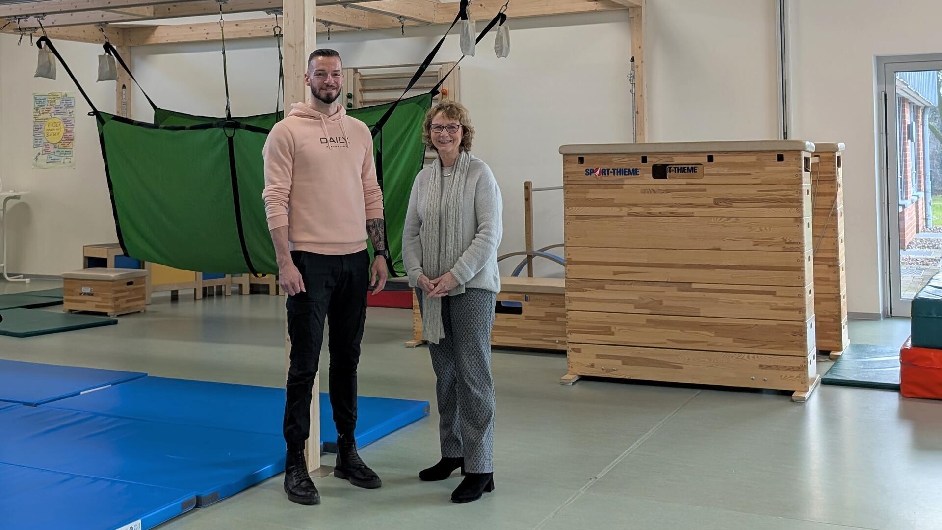 Ein Mann und eine Frau stehen in einer Turnhalle.