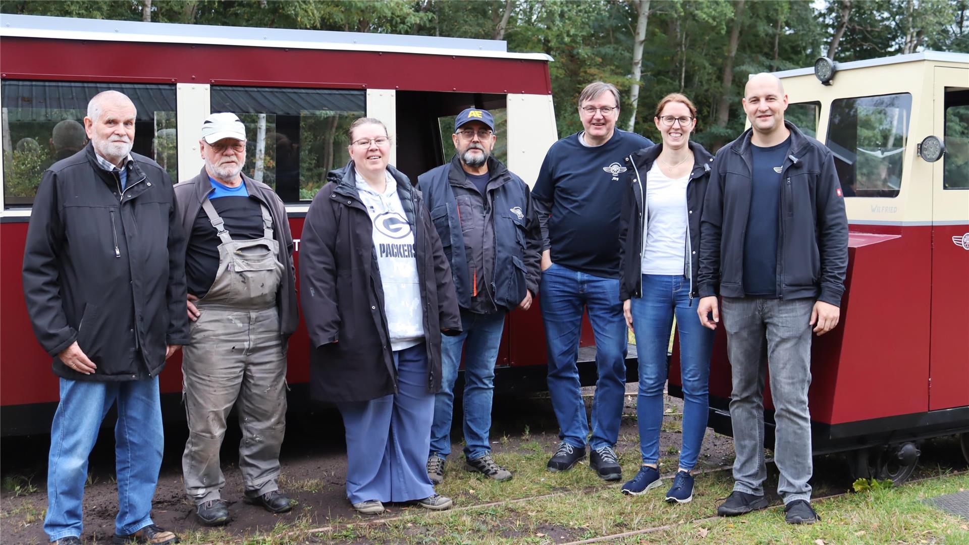 Gruppe von Menschen vor roter Eisenbahn