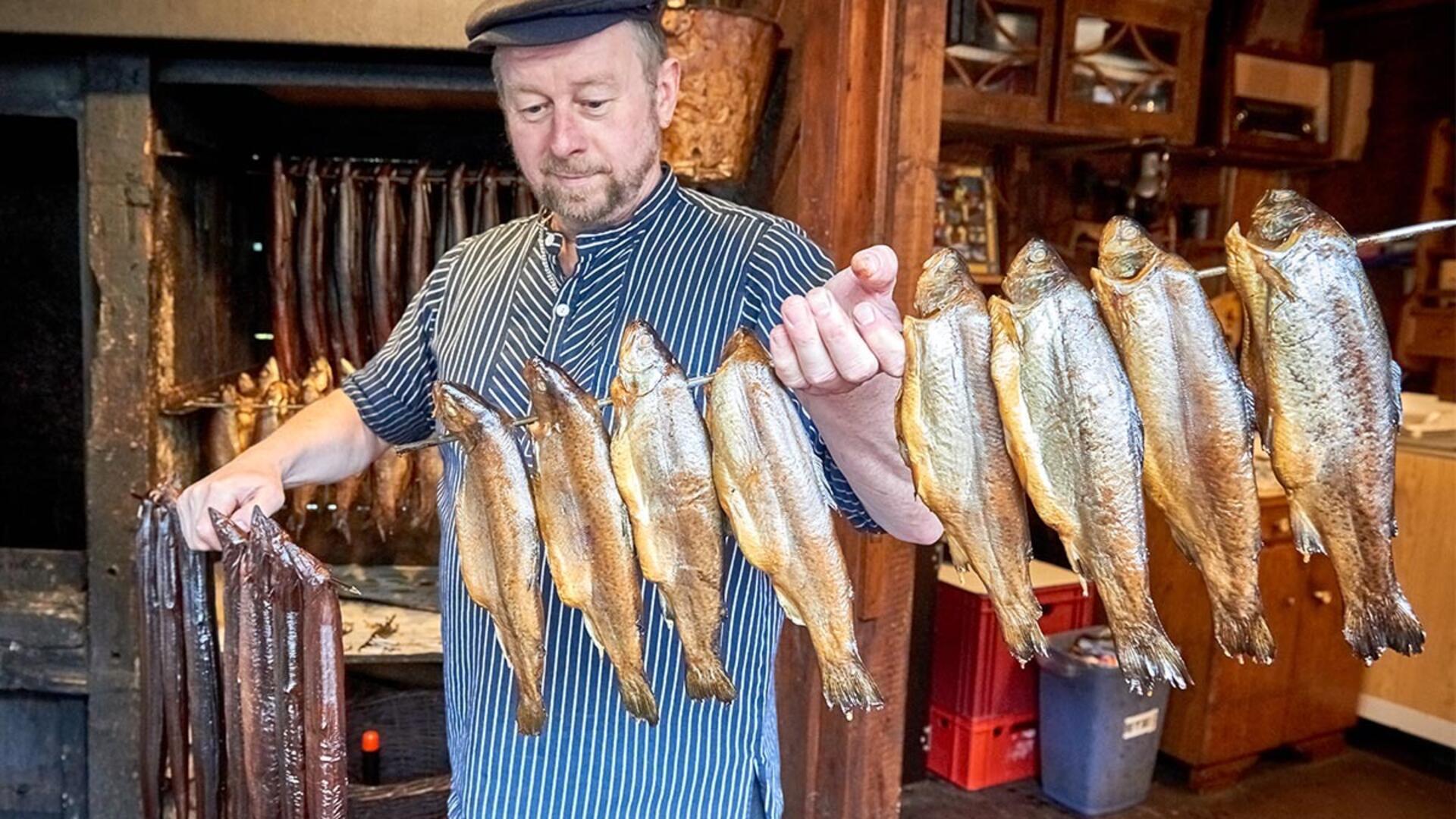 Ein Mann, der Fisch auf eine Stange sticht