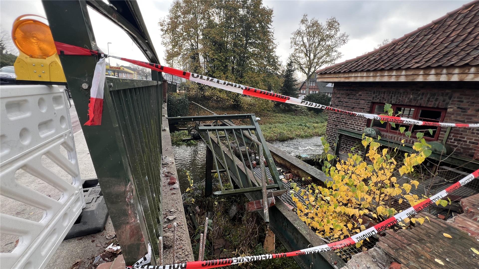 Kaputte Gitter, ein rotes Backsteinhaus und rot-weiße Absperrbänder.