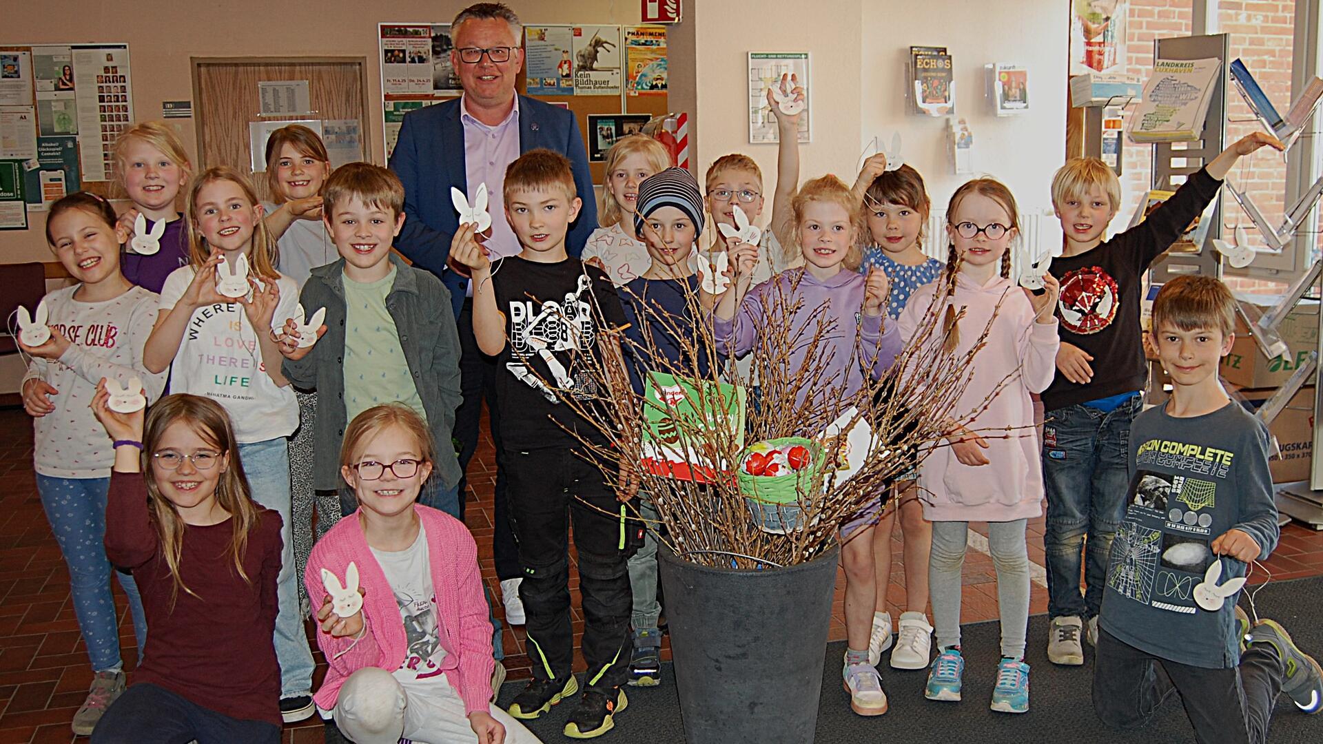 Viele Kinder und ein Erwachsener stehen in einer Gruppe zusammen.