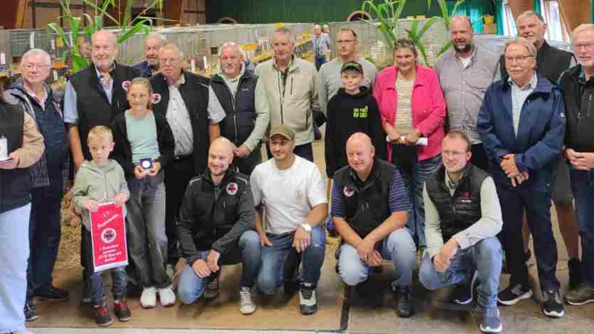 Gruppenfoto mit vielen Menschen. Die Landesjungtierschau des Landesverbands Hannover in Sandbostel lockte zahlreiche Besucher und Aussteller an. Züchter aus der Region überzeugten mit starken Ergebnissen und vielen Meistertiteln.