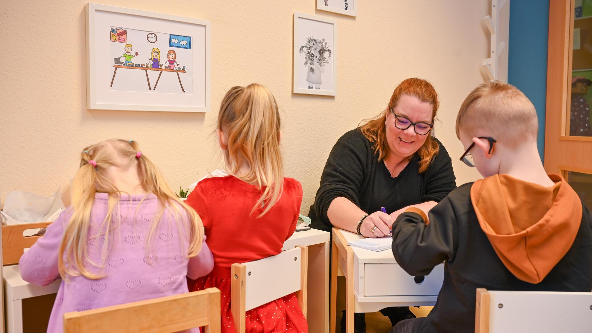 Kinder arbeiten an einem Tisch im Kinderbüro der Kindertagesstätte "Pfiffikus" in Bremerhaven