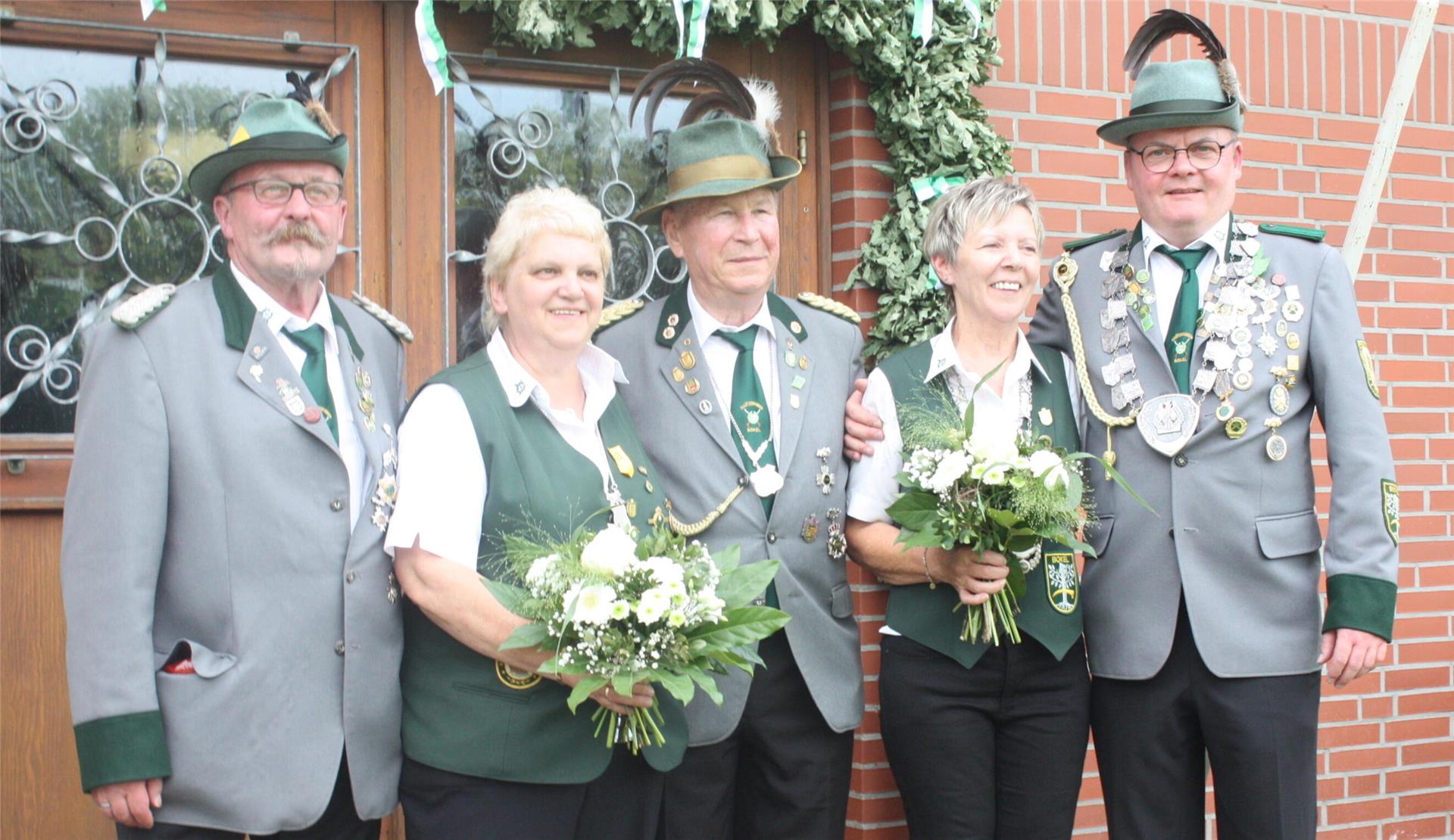 Gruppenfoto von fünf Mitgliedern des Schützenvereins Bokel in traditioneller Uniform. Zwei Frauen halten Blumensträuße, die Männer tragen Schützenorden.