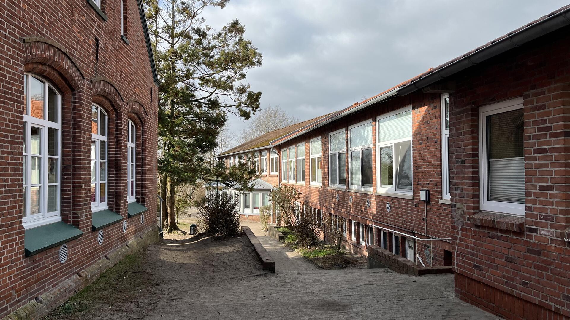 Die Midlumer Grundschule besteht schon jetzt aus mehreren Gebäudeteilen. Ab Frühjahr 2025 soll der jüngste Komplex (rechts) um ein weiteres Gebäude für die Mensa ergänzt werden.