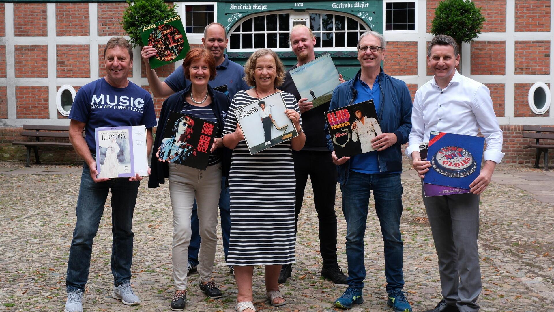 Die Mitglieder des Teams Netzwerk Plattenspende halten verschiedene Schallplatten in die Höhe.