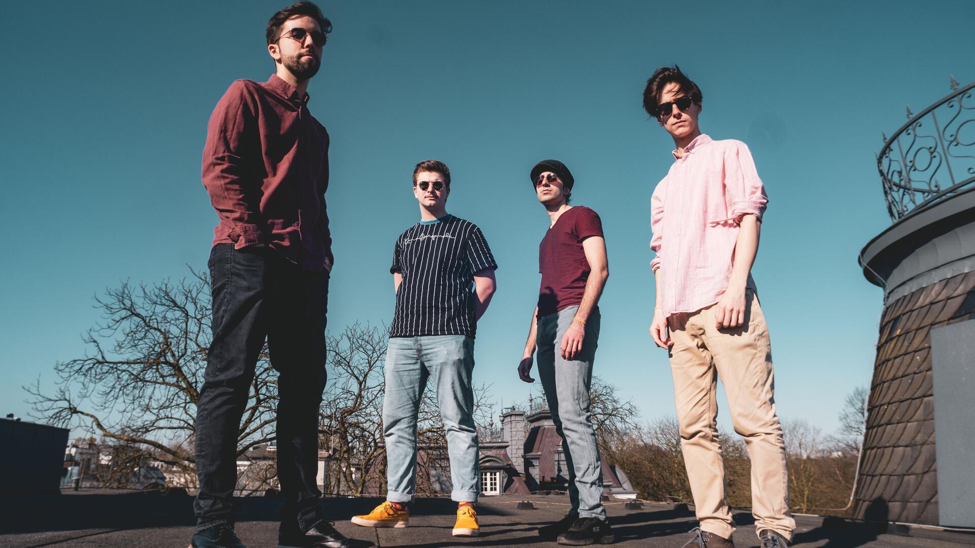 Vier Männer mit Sonnenbrillen stehen und gucken in die Kamera. Die Musiker von Maracutaia verbinden südamerikanische Rhythmen mit jazziger Leichtigkeit und zeigen auf der Bühne ihre gemeinsame Leidenschaft für brasilianische Musik. 