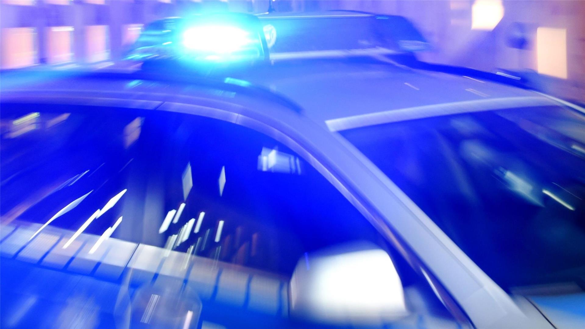 Ein Streifenwagen der Polizei steht mit eingeschaltetem Blaulicht auf der Straße.