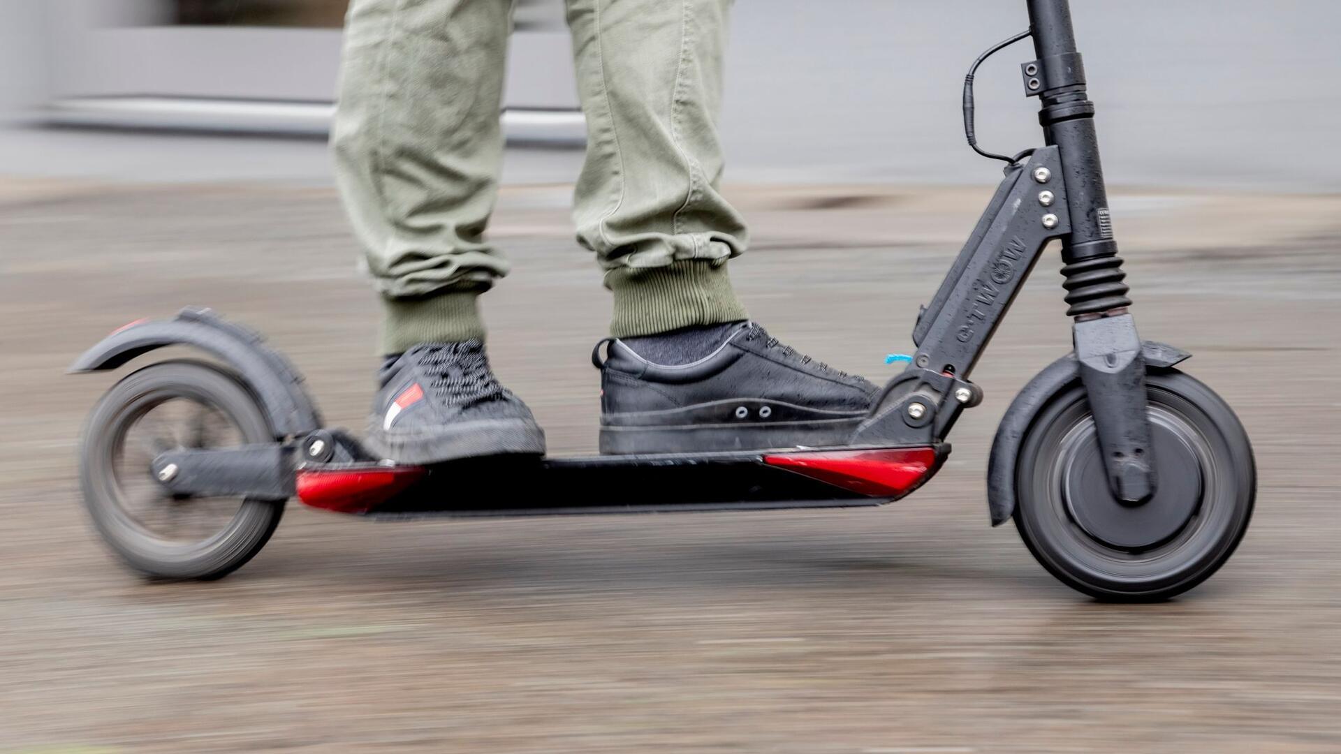  Ein Mann fährt mit einem E-Scooter.