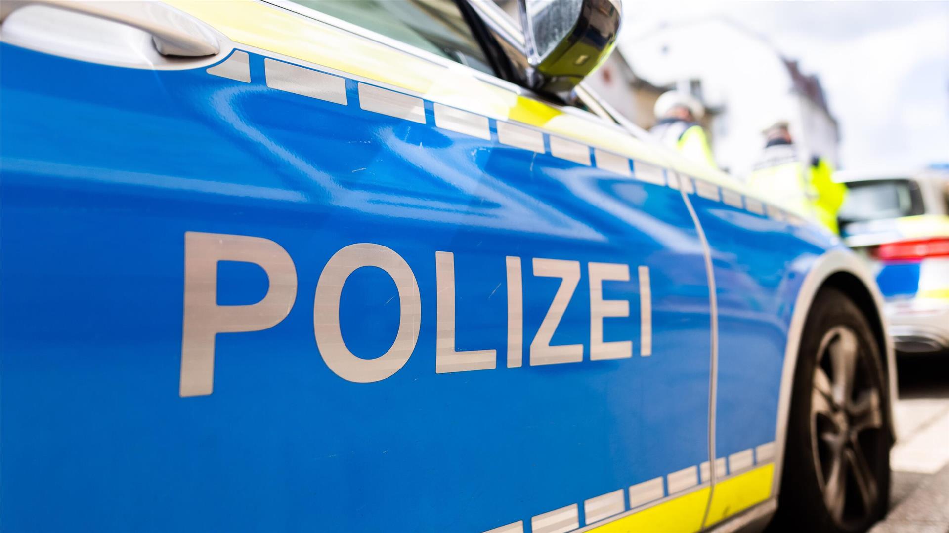Zwei Einsatzfahrzeuge der Polizei stehen in Freiburg am Straßenrand.