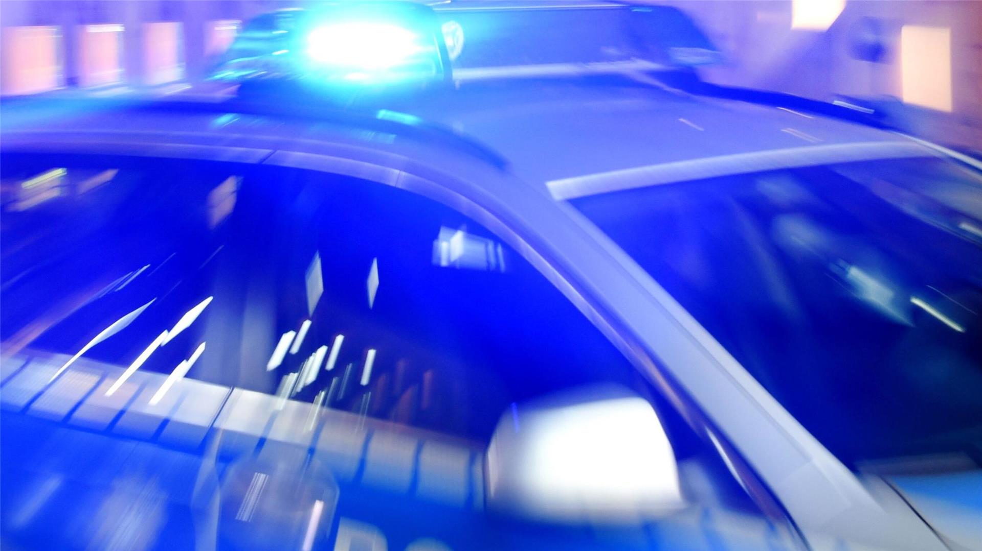 Ein Streifenwagen der Polizei steht mit eingeschaltetem Blaulicht auf der Straße.