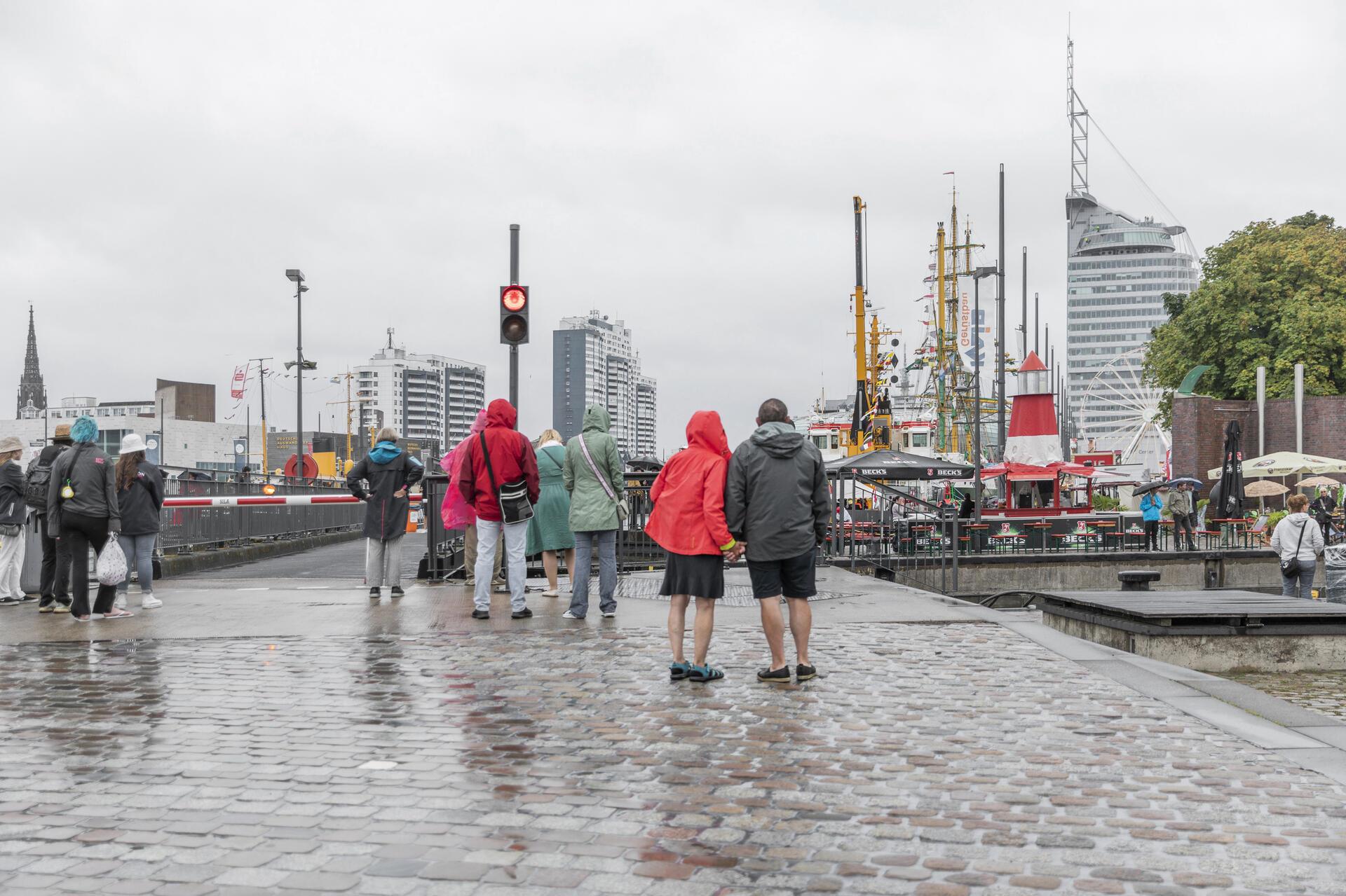 Menschen im Regen in einer Stadt. 