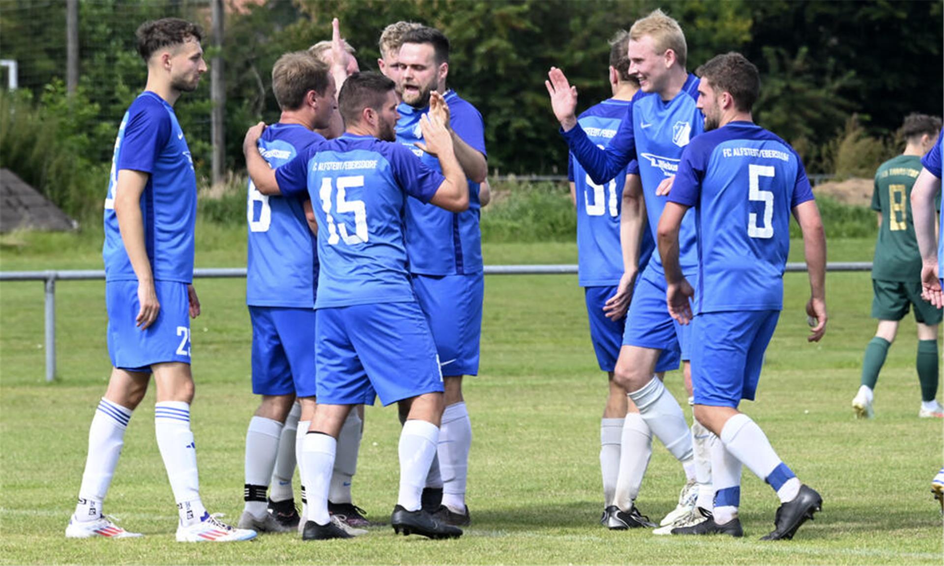 Die Spieler des FC Alfstedt/Ebersdorf feiern das 2:0 und „Vorbereiter“ Lars Rademacher (Nr. 15).