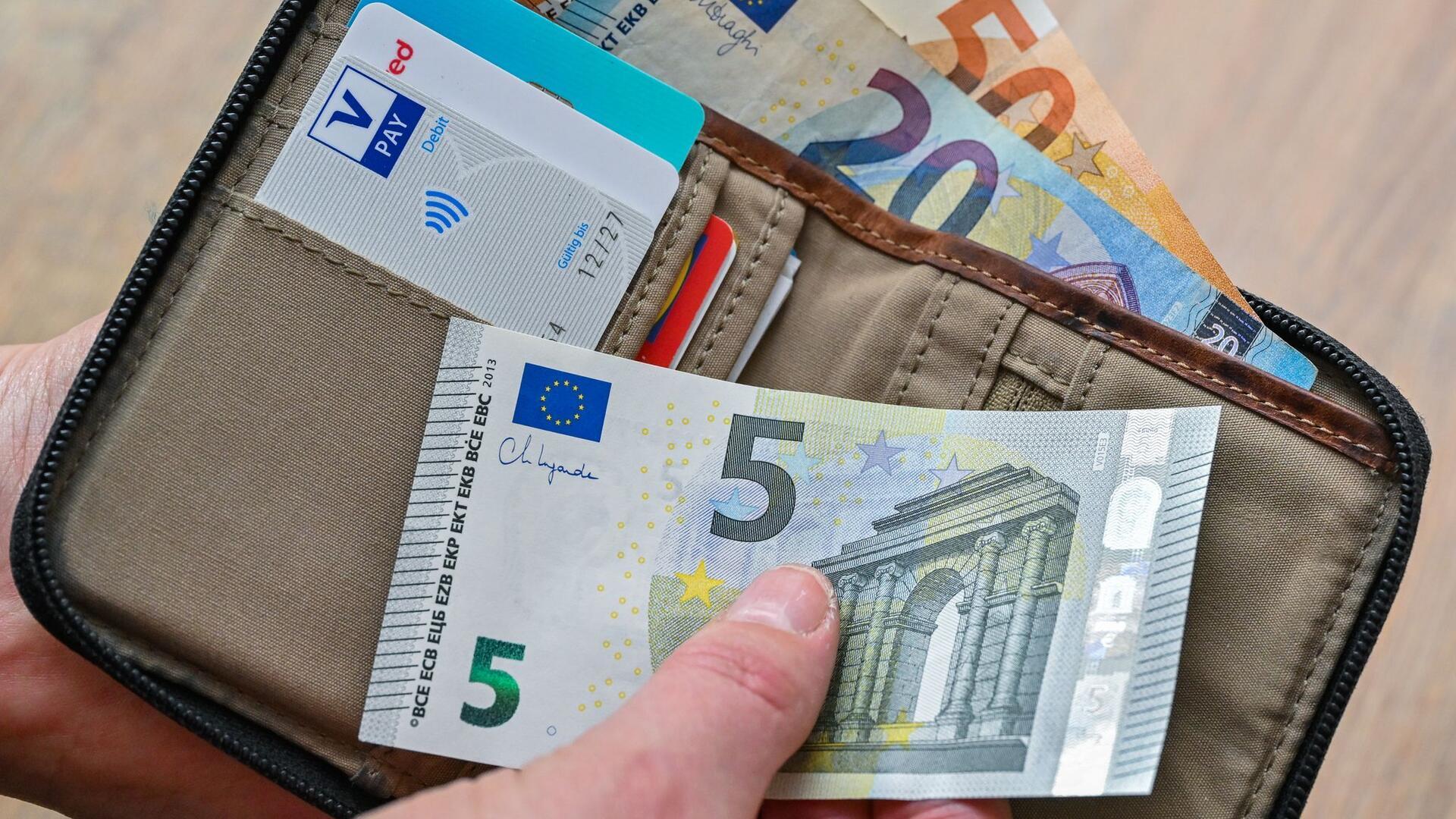 Eine Frau hält Geldscheine in der Hand.