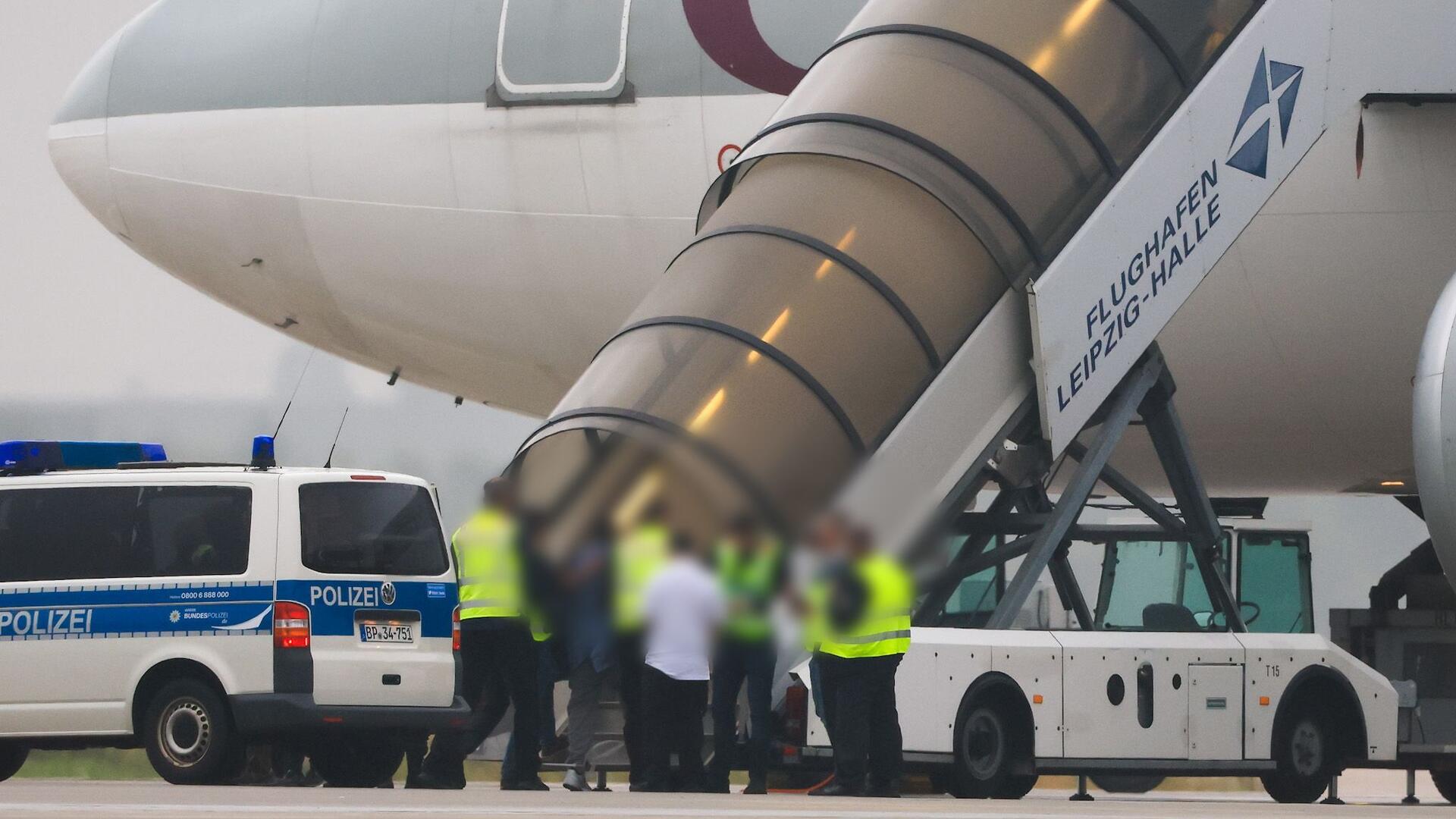 Abschiebungen aus Bremerhaven und Bremen verdreifacht: Fragen nach Polizeigewalt Polizisten begleiten Personen in ein Flugzeug.