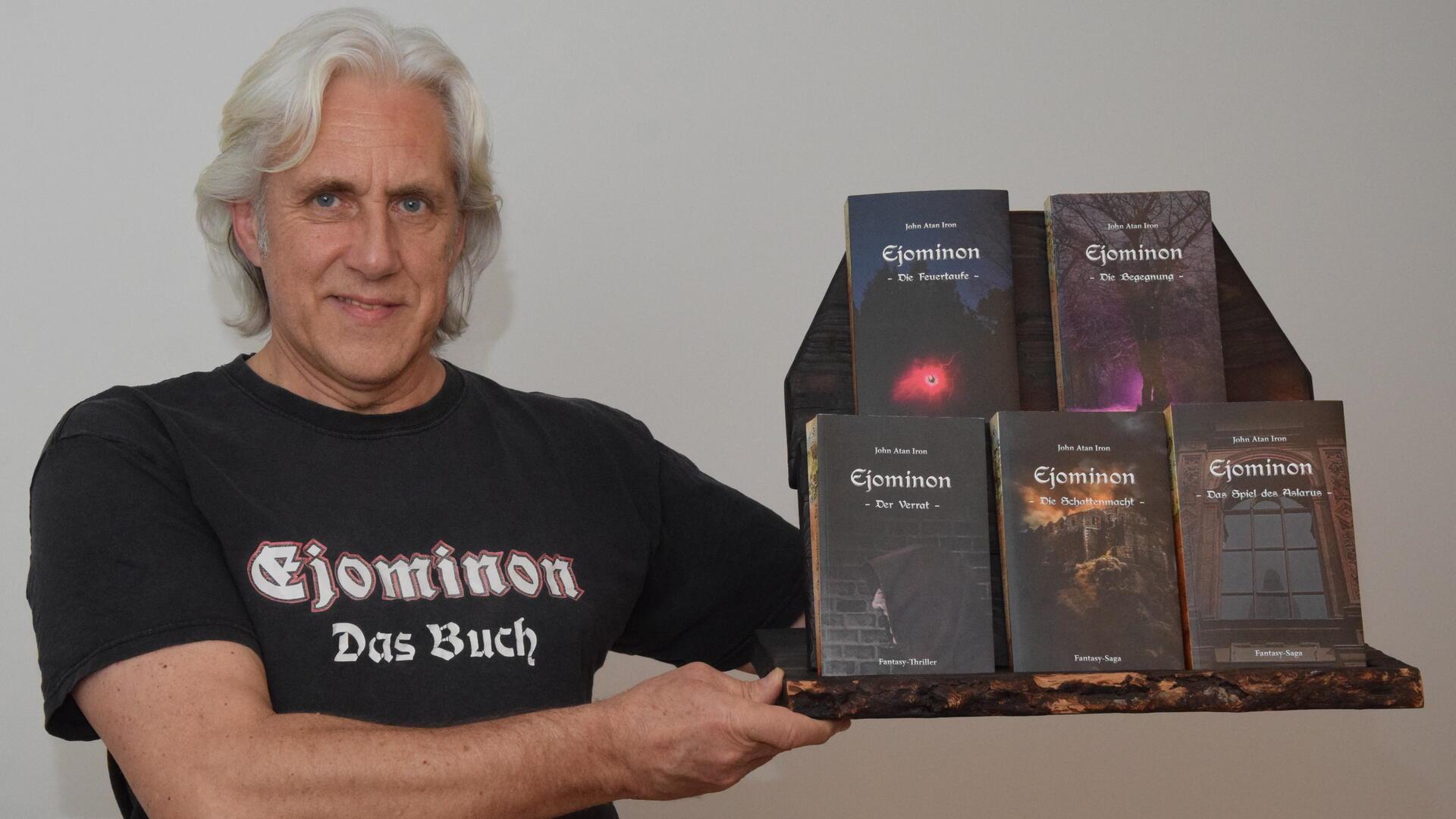 Autor John Atan Iron mit den fünf Büchern der Fantasy-Saga.