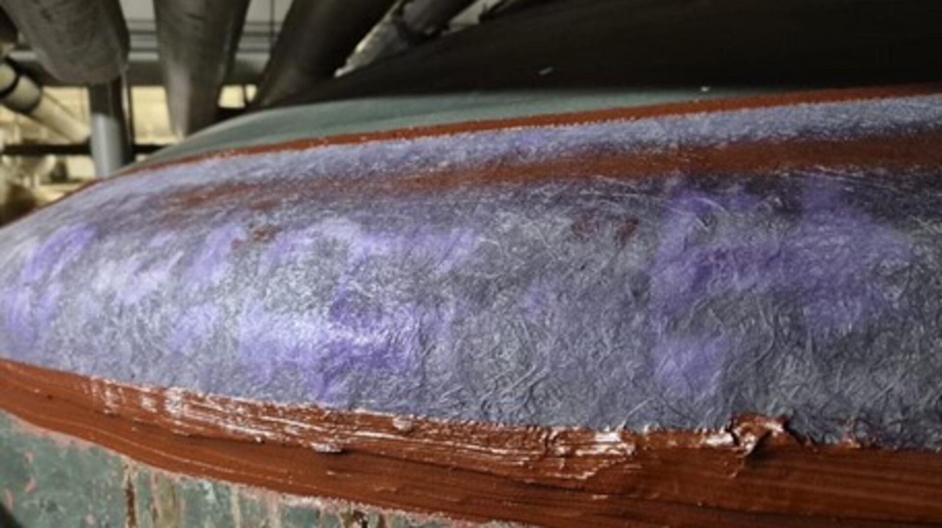 Eine Detailaufnahme zeigt frische, braunrote Klebestellen an einem Filterbehälter.