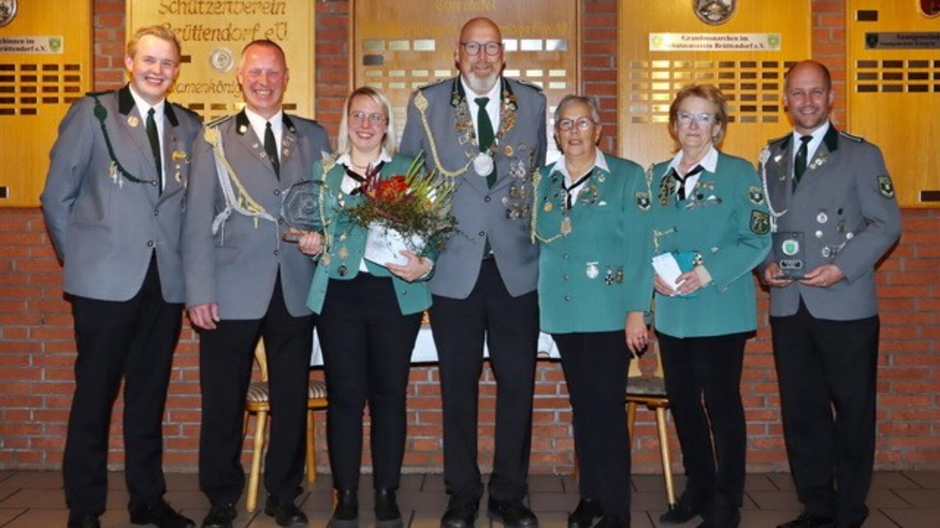 Menschen in Schützenuniform stehen nebeneinander. 