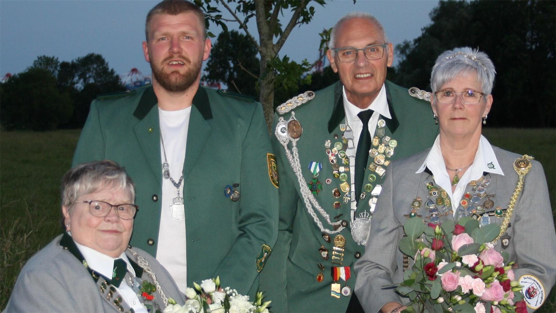 Vier Menschen in Schützenuniform. Die neuen Titelträger des Schützenvereins Imsum von 1924 präsentieren sich mit Blumensträußen und Schützenketten (von links): Marion Schildknecht, Mathis Kracke sowie Peter Geiß und Elke Geiß.