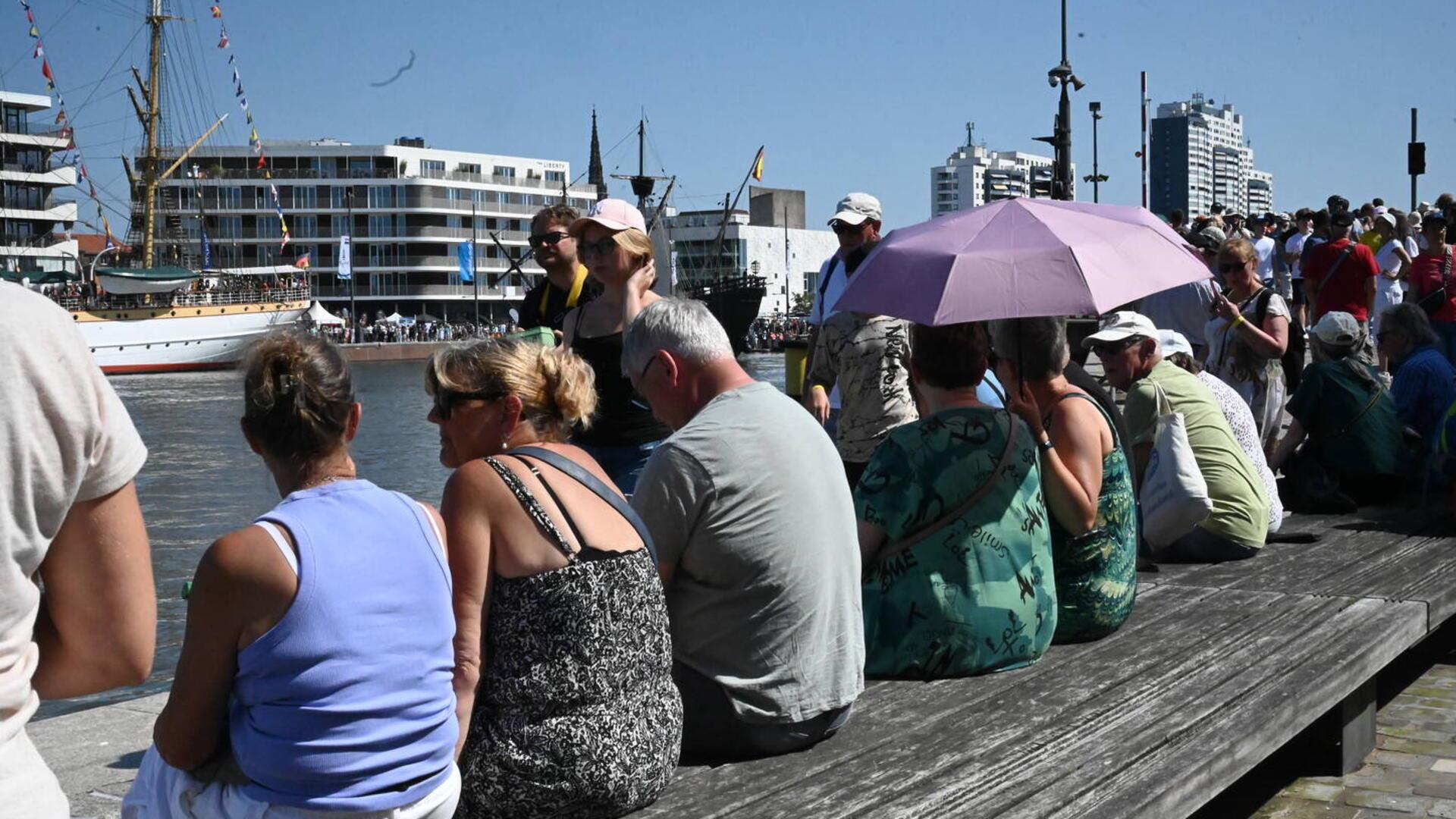 Menschen auf einer Bank am Wasser.