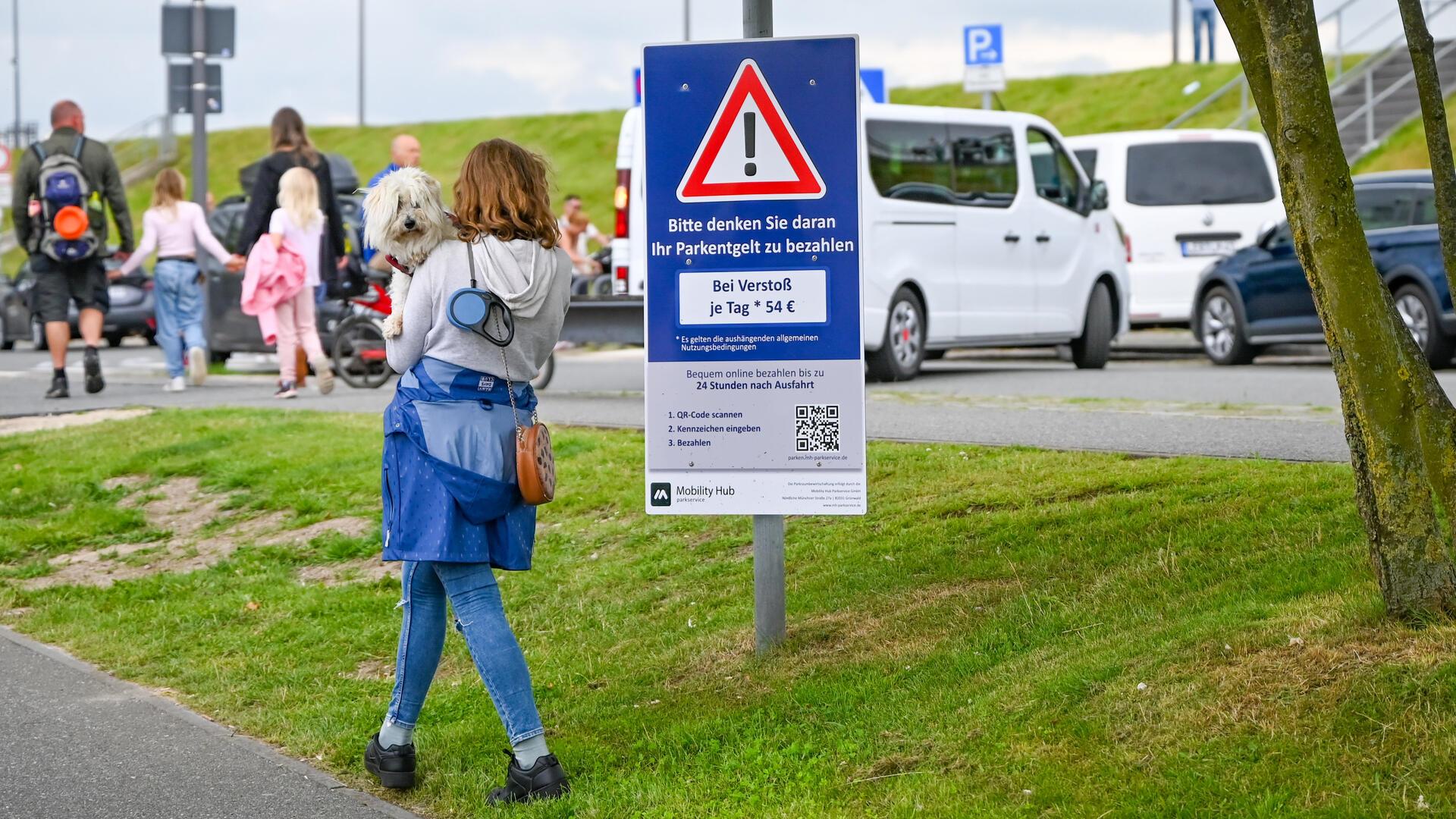 Frau schaut auf das Hinweisschild am Neuen Hafen