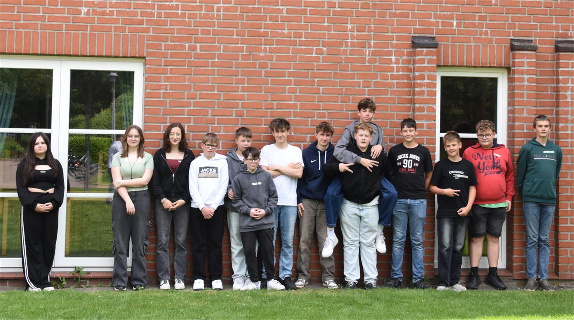 Eine Gruppe Schüler steht vor einem Gebäude.