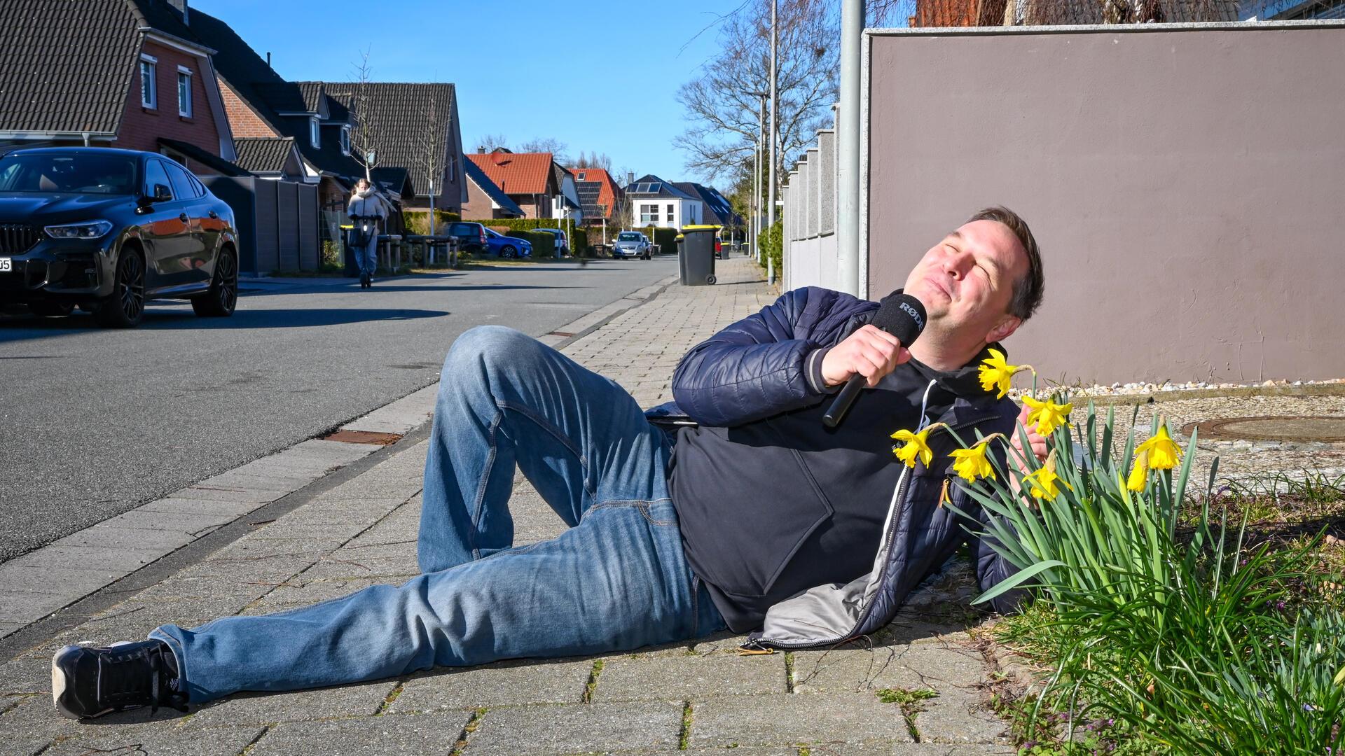 Ein Mann sonnt sich auf der Straße. 