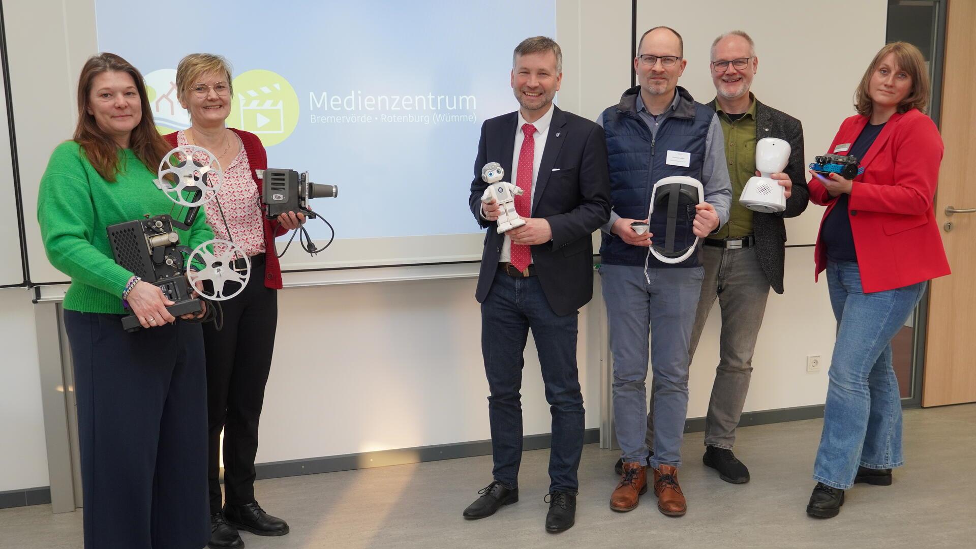 Dr. Torsten Lühring (Dritter von links), Claus Lange vom Niedersächsischen Landesinstitut für schulische Qualitätsentwicklung sowie Medienzentrums-Leiter Cord Gerken (Zweiter von rechts) und sein Team stellen das Angebot des Medienzentrums des Landkreises in Bremervörde vor. Längst wurden die alten Projektoren und Filmrollen (links) aussortiert und durch VR-Brille, Roboter und Co. ersetzt. 