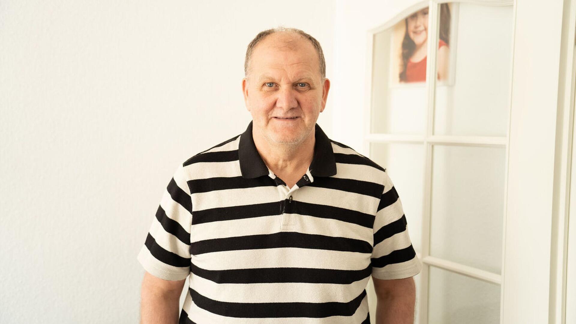 älterer Mann in gestreiftem Polo-Shirt
