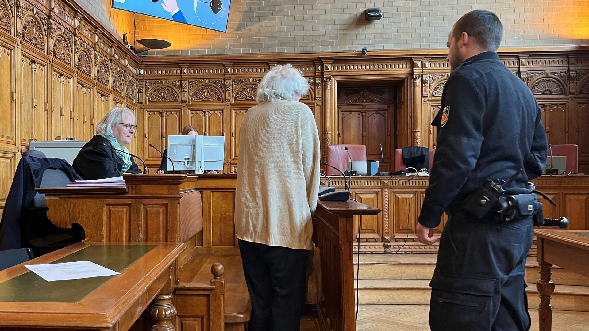 Mann im Gerichtssaal neben einem Justizbeamten. 
