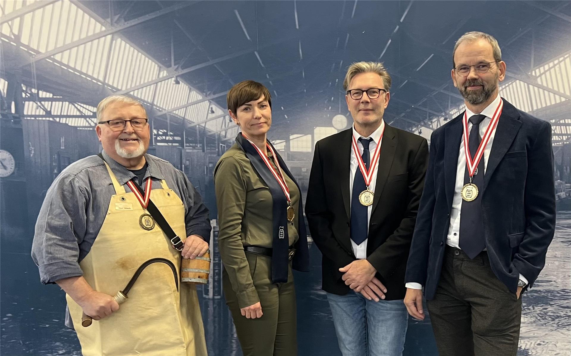 Gruppenfoto : drei Herren und eine Frau mit kurzen Haaren gucken in die Kamera
