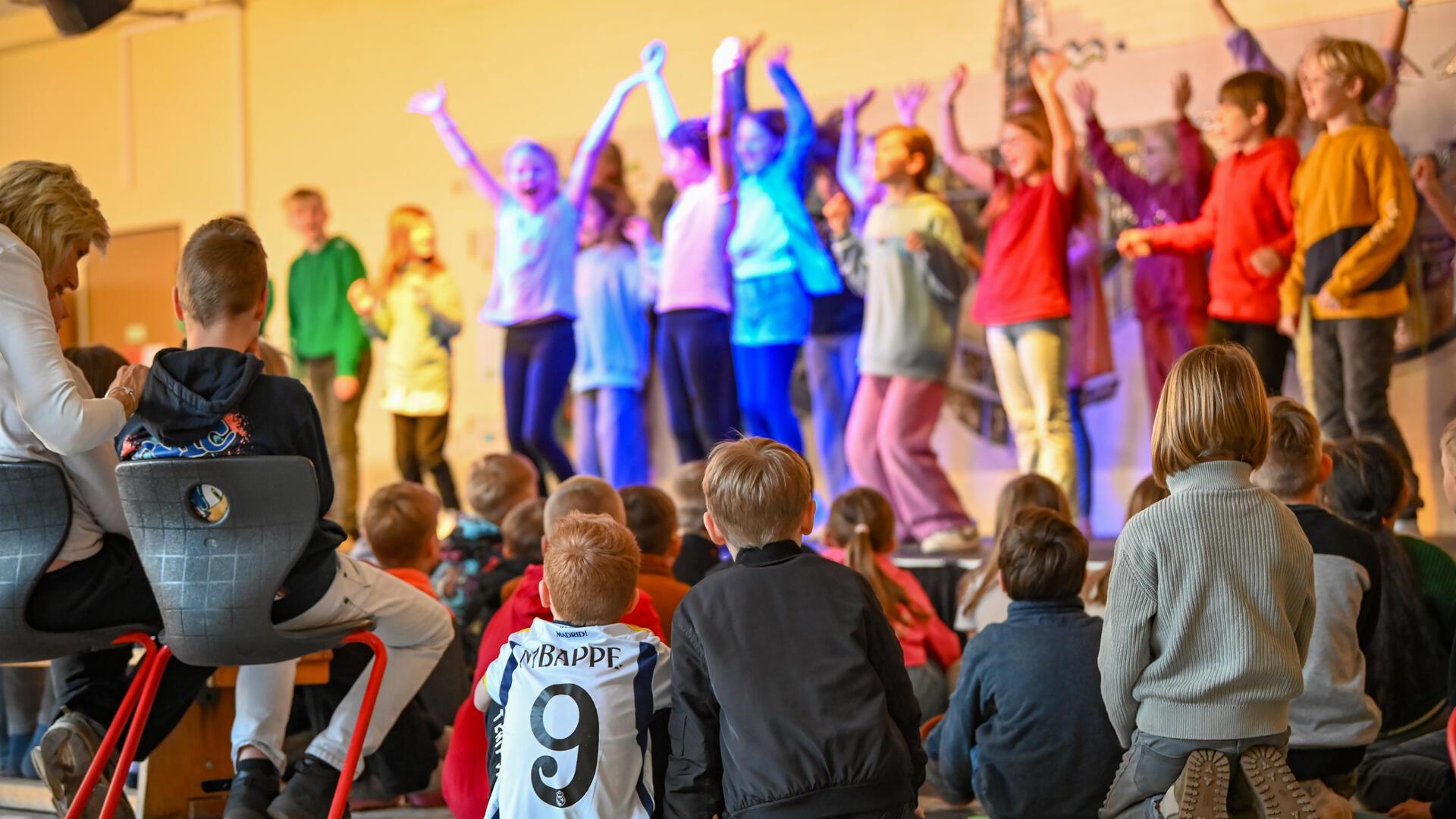 Tanzende und singende Schüler. Ein paar andere schauen ihnen dabei zu.