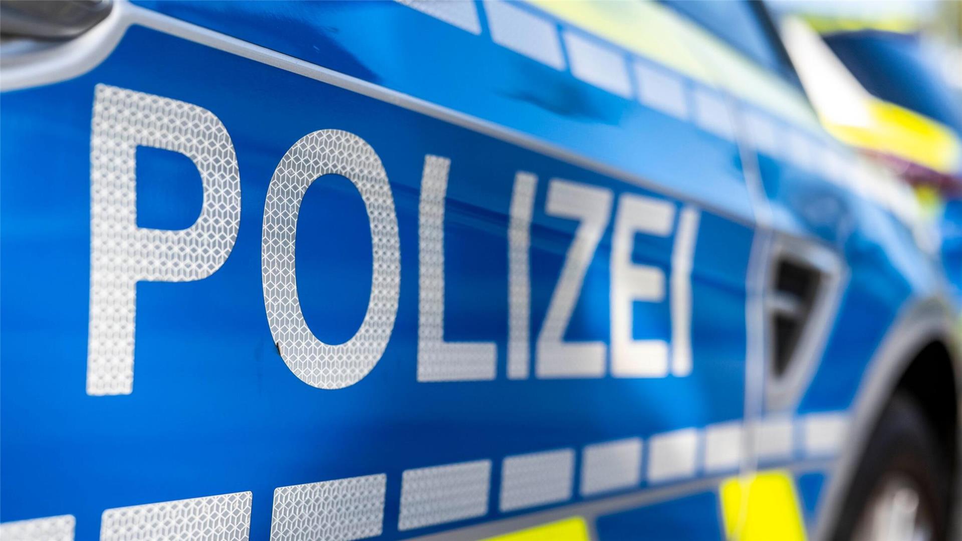 An der Tür von einem Streifenwagen steht der Schriftzug „Polizei“.