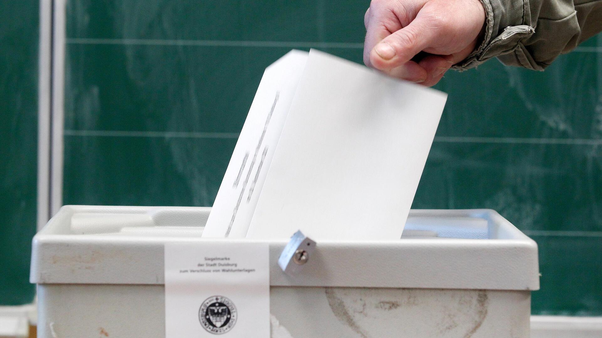 Ein Wähler wirft seinen Stimmzettel in einem Wahllokal in die Wahlurne. Die Auswirkungen der Wahlrechtsreform machen sich erst nach der Auszählung bemerkbar.
