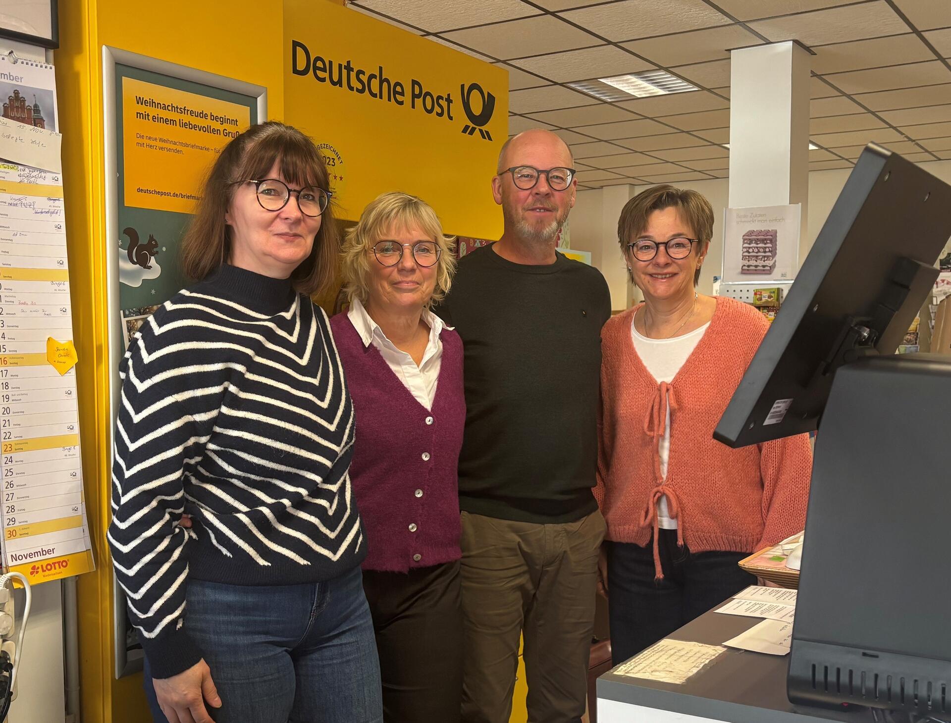 Drei Frauen und ein Mann blicken in die Kamera.