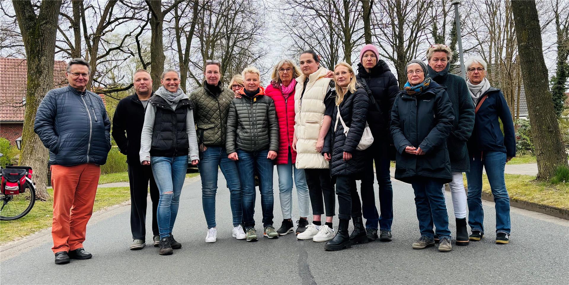 Männer und Frauen blicken in die Kamera.