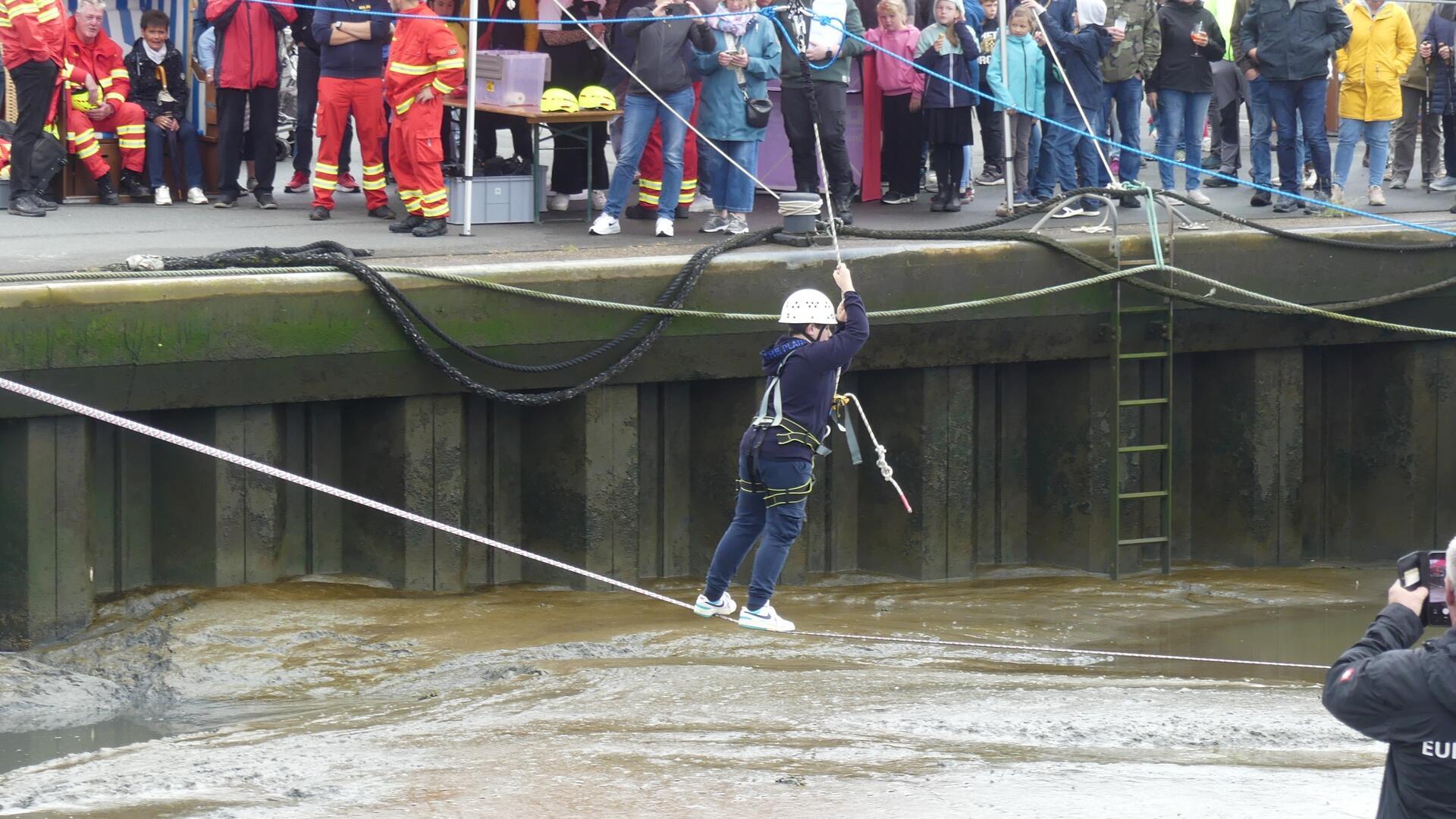Ein junger Teilnehmer versucht sich auf der Slackline über das Dorumer Hafenbecken.