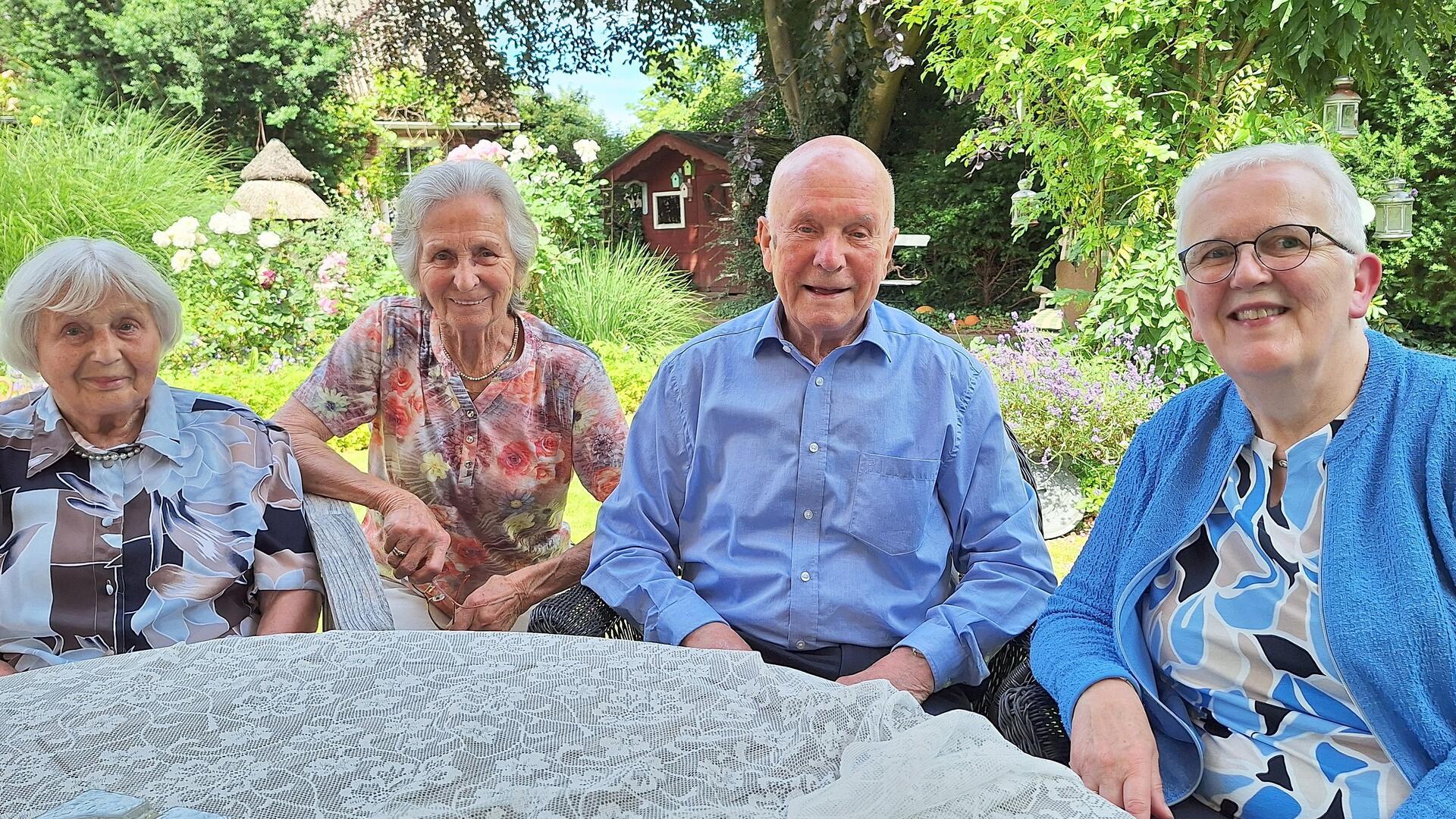 Drei Frauen und ein Mann sitzen an einem Tisch.