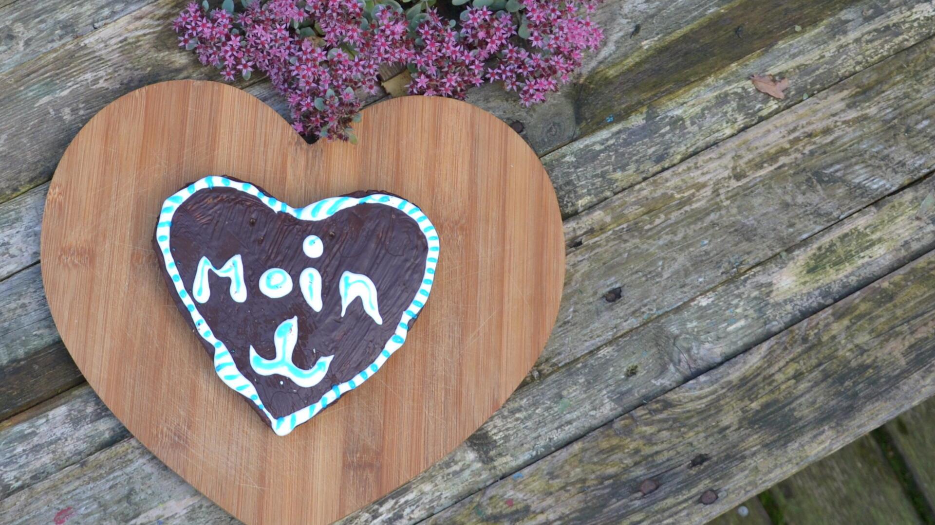 Kindheit und Kuchenduft - regnerische Tage ziehen mich in die Küche Ein Lebkuchenherz liegt auf einem Holzbrett.