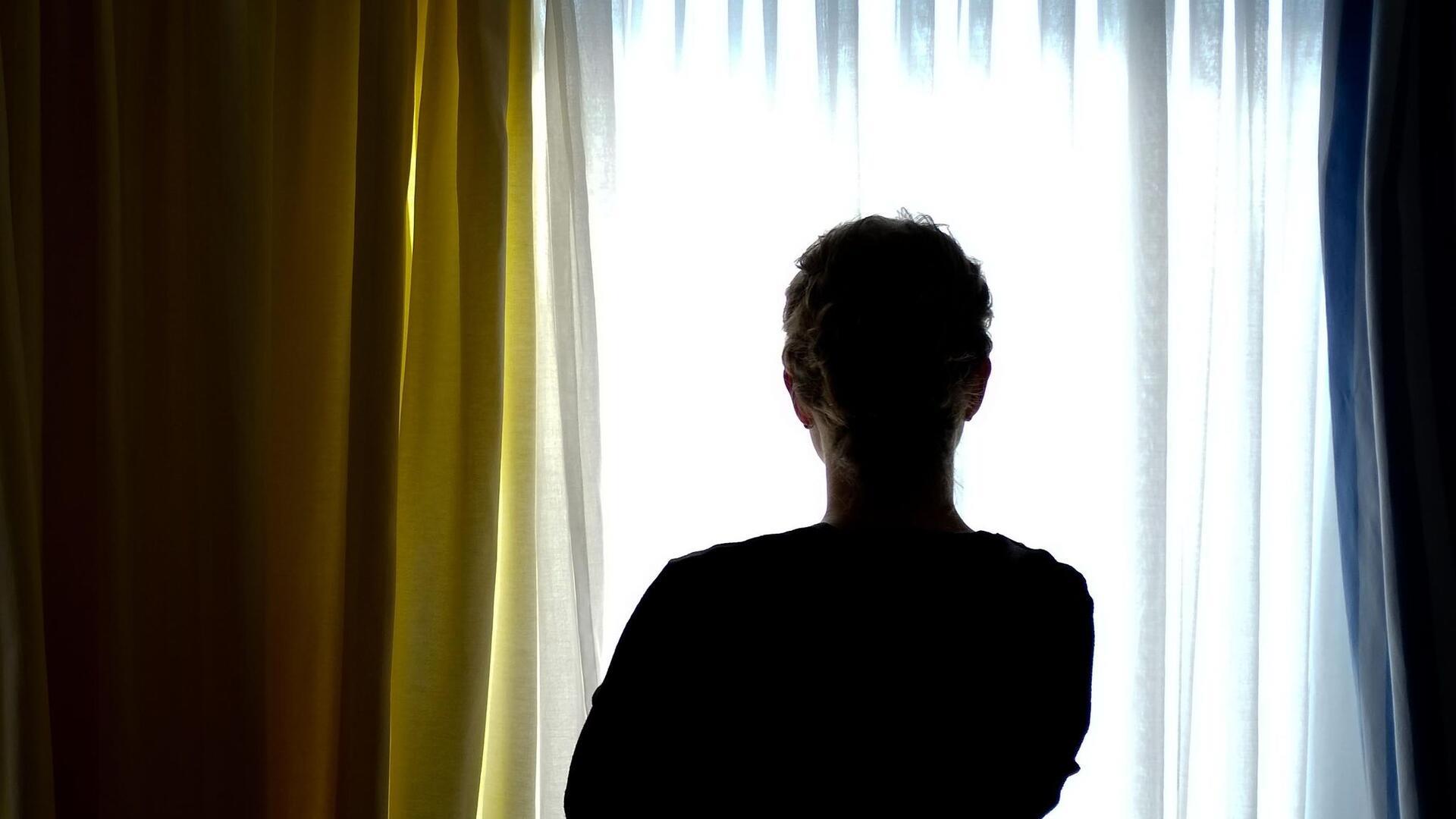 Eine Frau steht in einem Frauenhaus-Zimmer. 