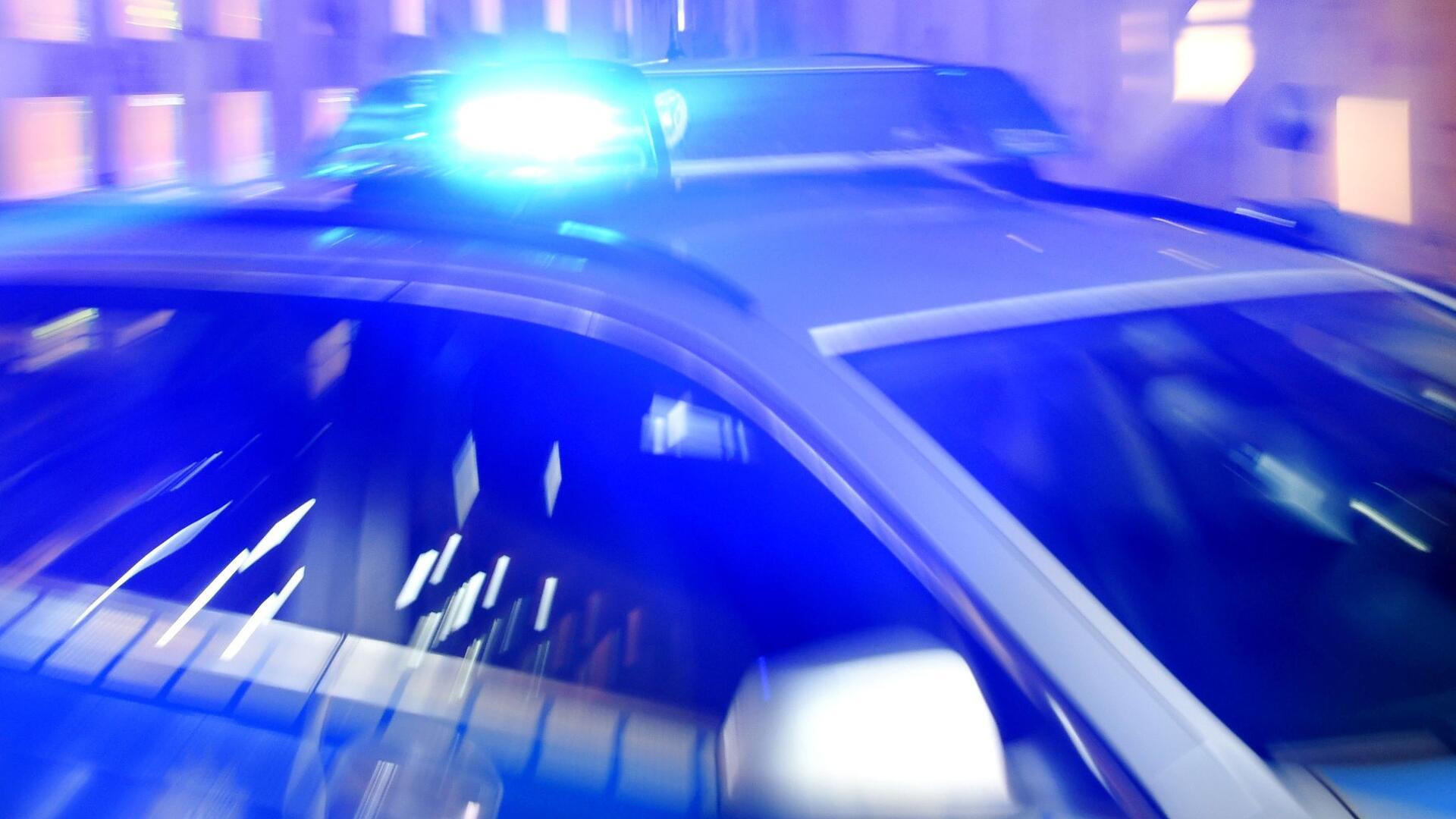 Auf dem Dach eines Polizeiwagens leuchtet das Blaulicht.