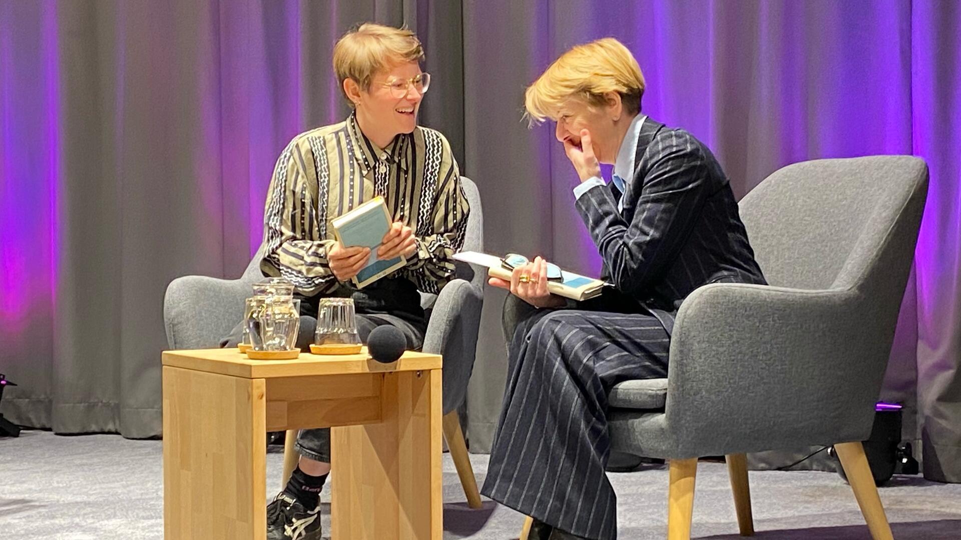 Eine schriftstellerische "Newcomerin" zu Gast beim 16. Literarischen Herbst der Stadtbibliothek Bremerhaven 2025: Thea Mengeler (links) liest aus ihrem neuen, erst zweiten Roman "Nach den Fähren", und erzählt im Gespräch mit Moderatorin Margarethe Seul-McGee, was eine verlassene Insel mit den wenigen darauf verbliebenen Menschen macht.