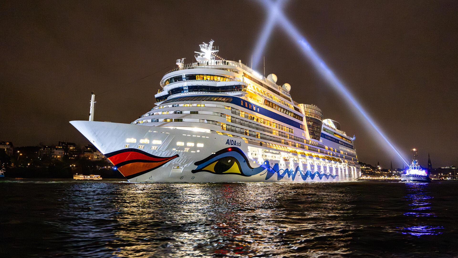 Ein Schiff fährt beleuchtet in der Dunkelheit