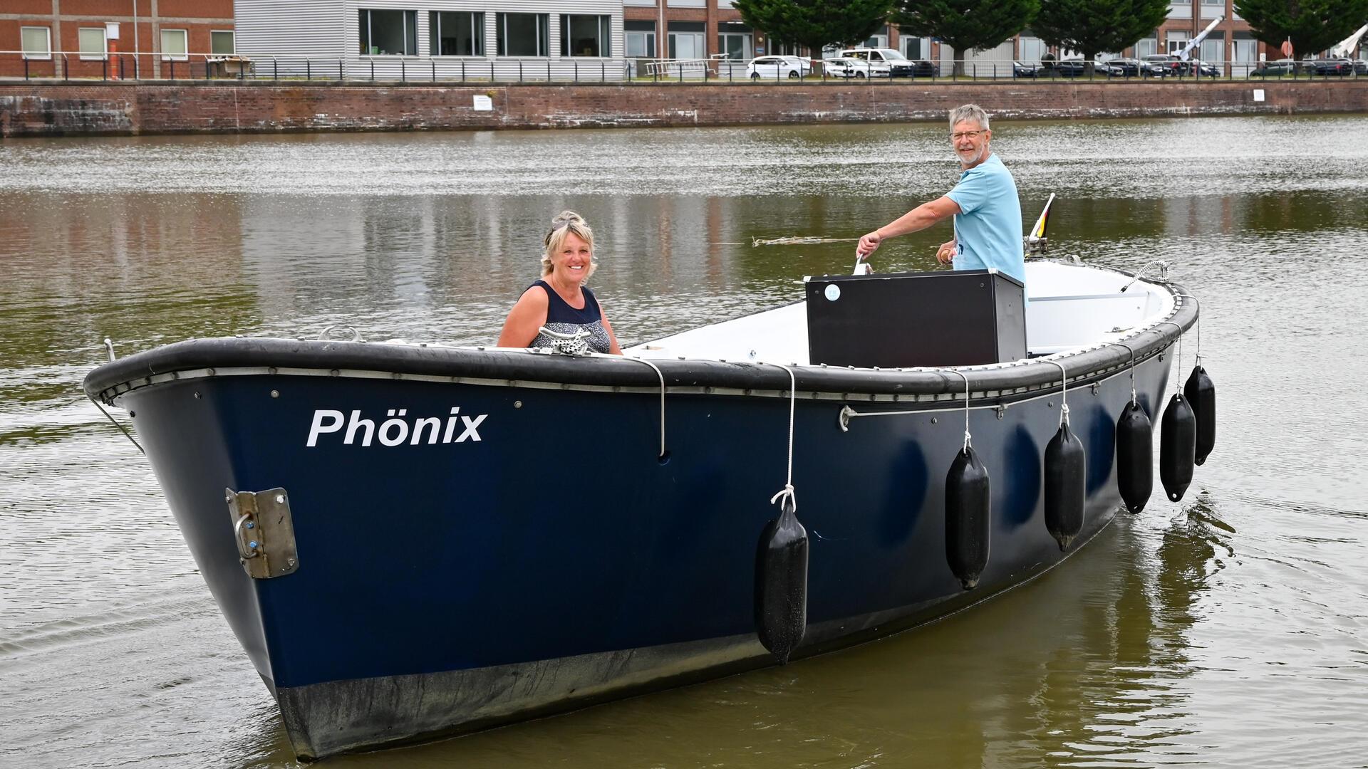 Zwei Menschen fahren in einem blauen Boot.
