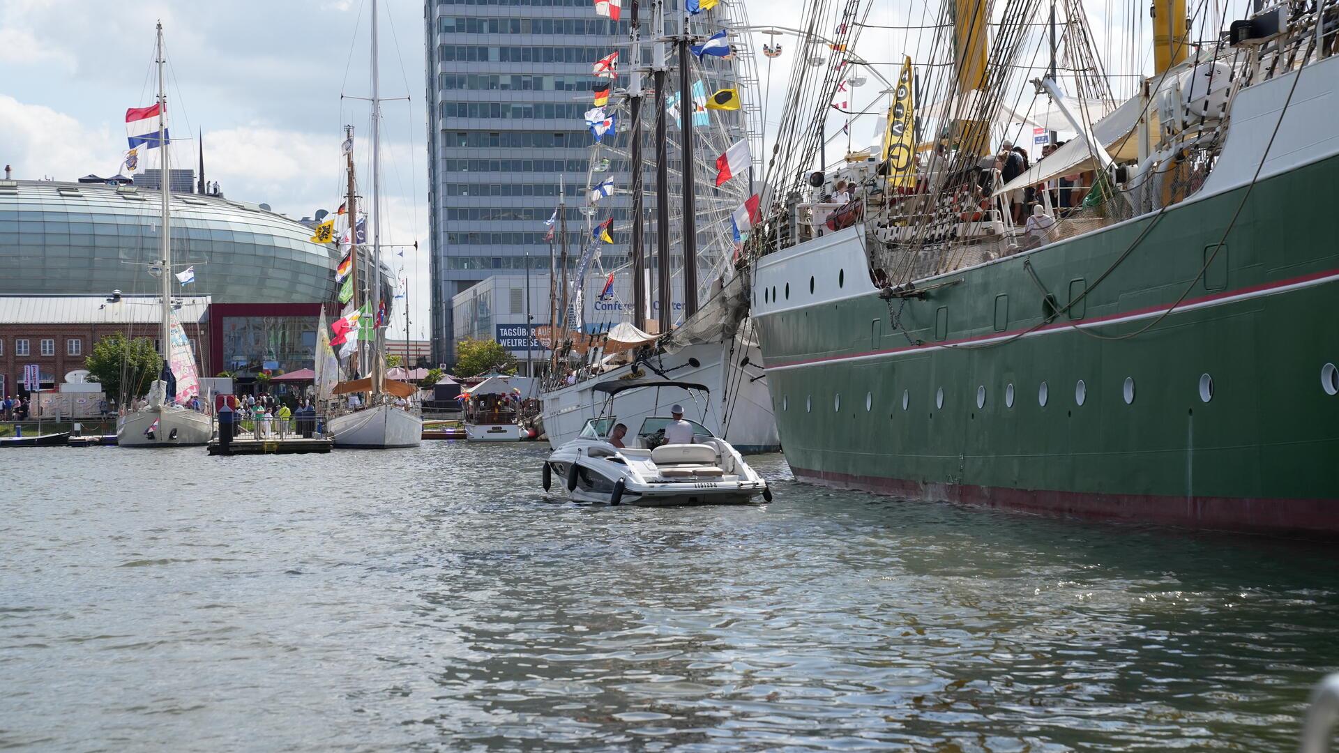 Ein Boot fährt auf der Sail 2025 in Bremerhaven entlang der "Alex II".