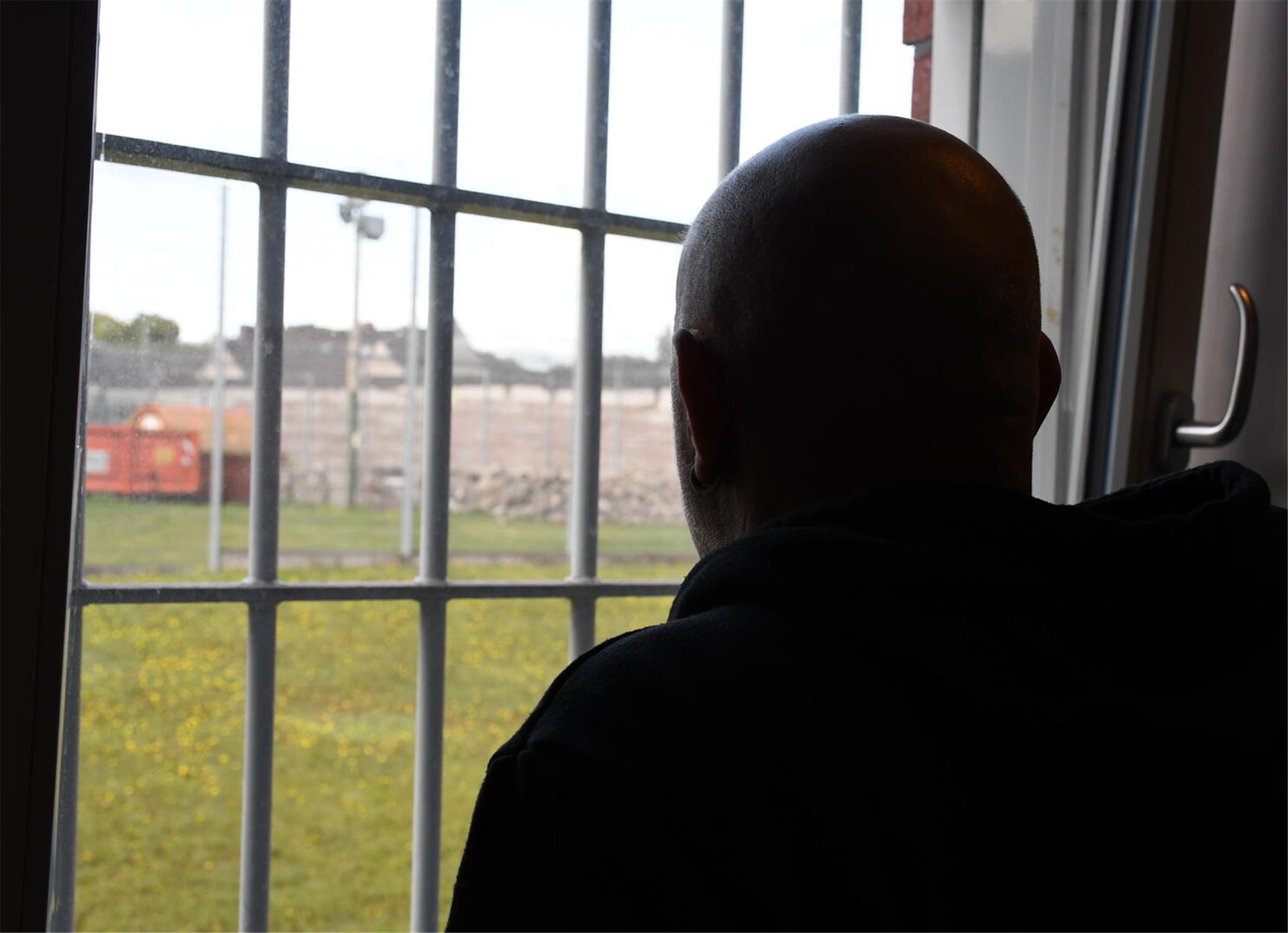 Mann am vergitterten Fenster. 
