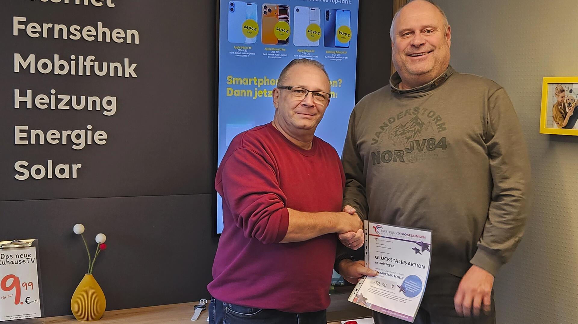 Erster Goldtaler des Jahres: SatCom-Geschäftsführer Harald Stiebitz (rechts) übergibt einen 50-Euro-Einkaufsgutschein als Sofortgewinn an seinen Kunden Ulrich Andres.